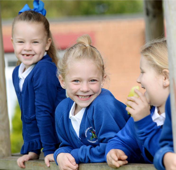 Three pupils outside smiling and laughing